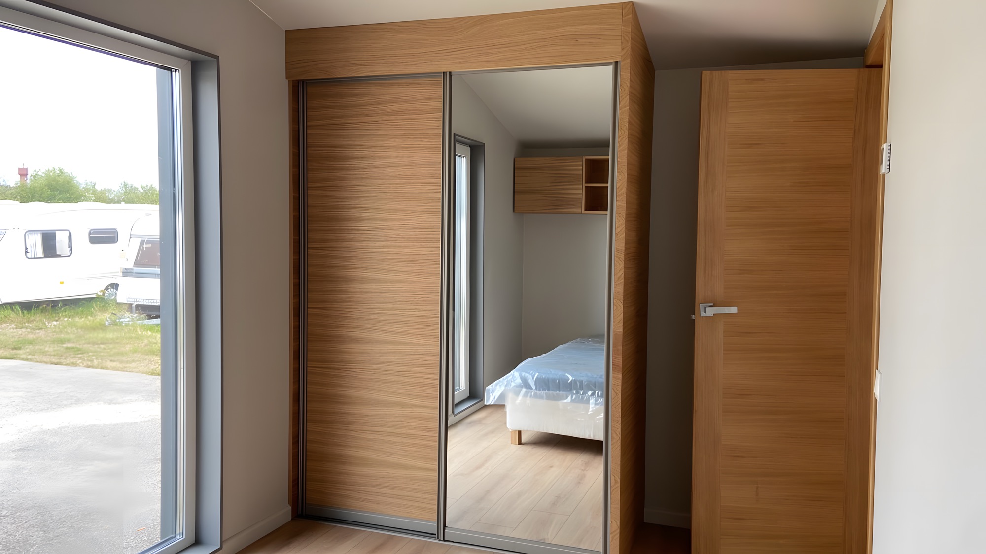 Schranklösung und Schlafbereich mit ruhiger Materialität im Innenraum.